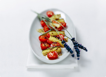 Schüssel mit Tomaten-Zucchini-Salat und Lavendel